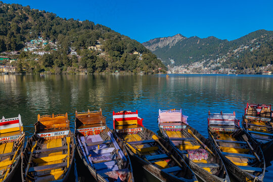 Nainital lake — colourful wooden boats under blue sky with mountain town