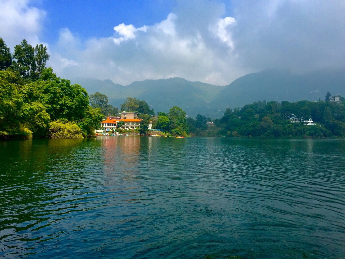 Naukuchiatal lake — colourful boats and swan pedal boats on calm water